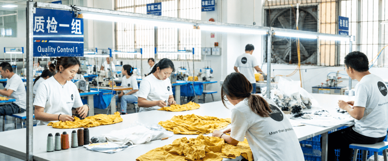 Quality control staff inspecting garments at the Lilian Apparel factory.